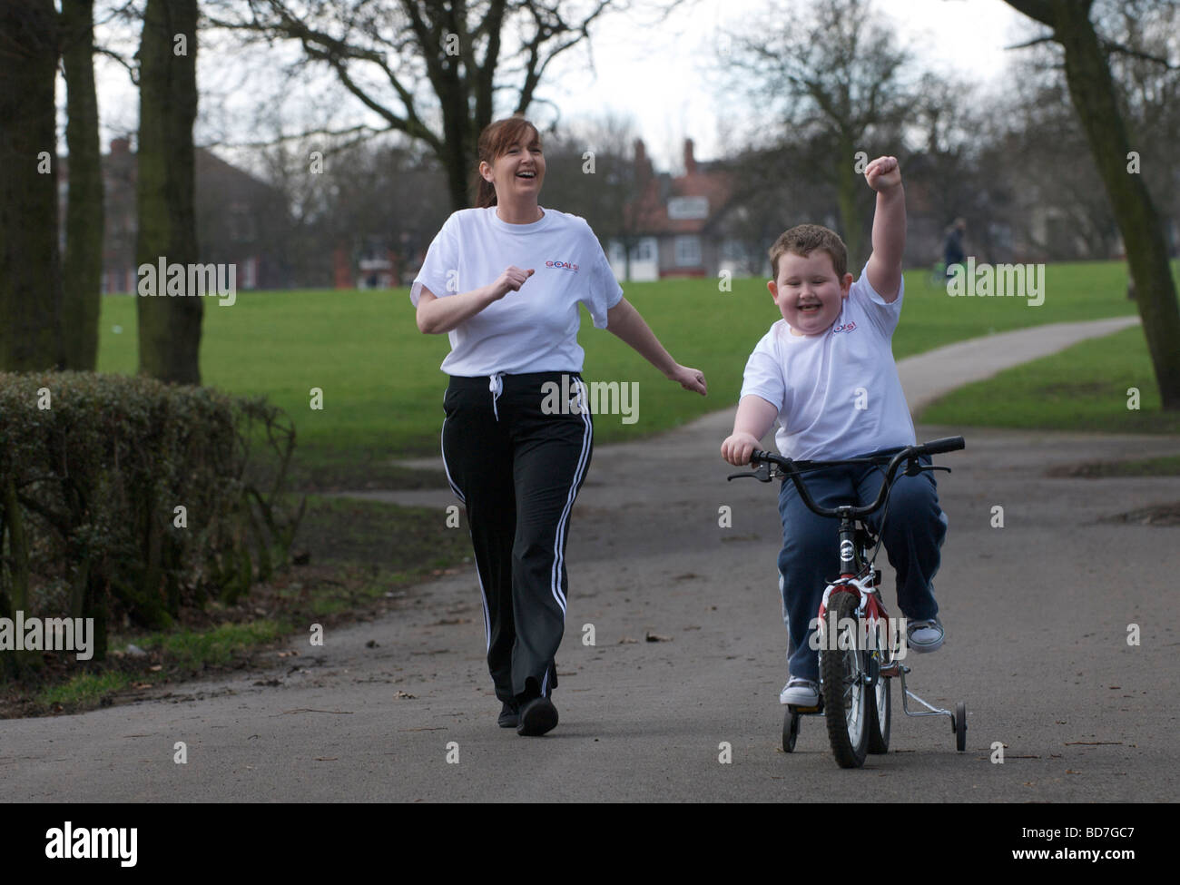 Mutter und übergewichtige Kind auf einen gesunden Lebensstil-Programm "Ziele" spazieren fahren in einem Park in Liverpool. Stockfoto