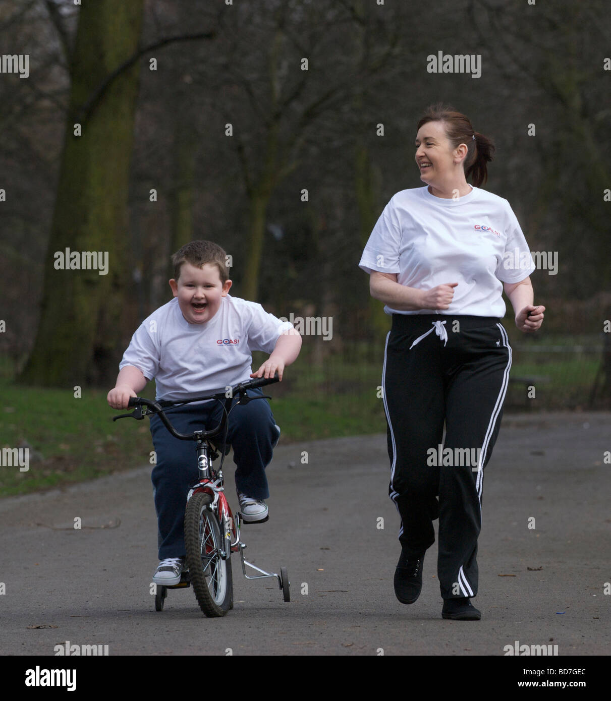 Mutter und übergewichtige Kind auf einen gesunden Lebensstil-Programm "Ziele" spazieren fahren in einem Park in Liverpool. Stockfoto