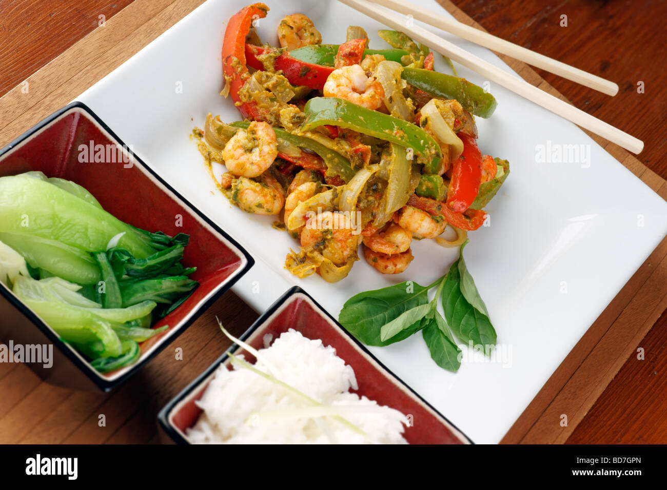Stir-Fried Thai Stil Garnelen in Chili und Basilikum Paste Sauce Paprika mit Pak-Choi und Reis Stockfoto