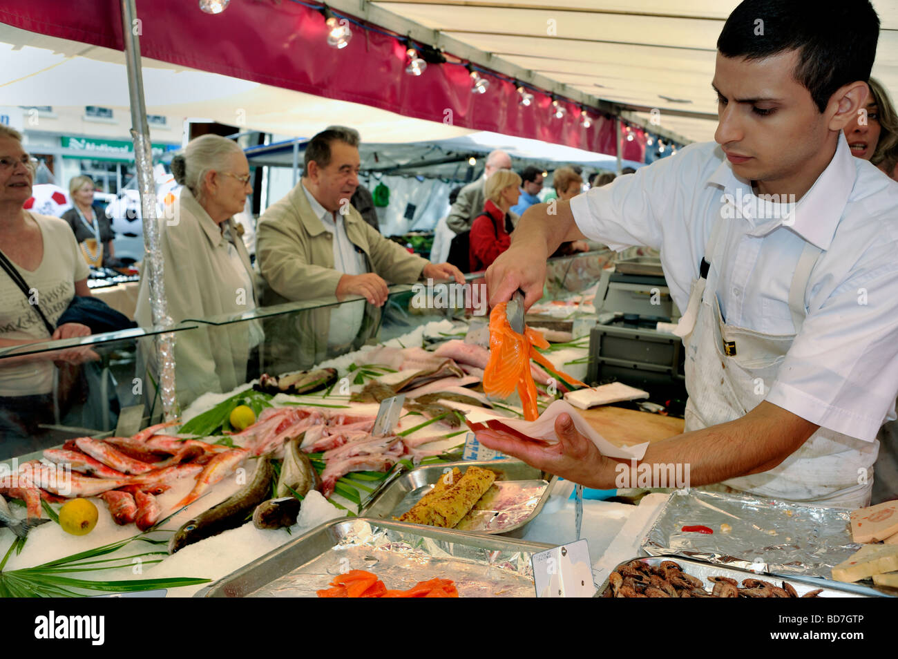 Paris Frankreich, Menschen, Shopping in außerhalb öffentlicher Lebensmittelmarkt, Stall, Display, frischen Fisch junge männliche Angestellte Portion Lachs, Straße Stockfoto