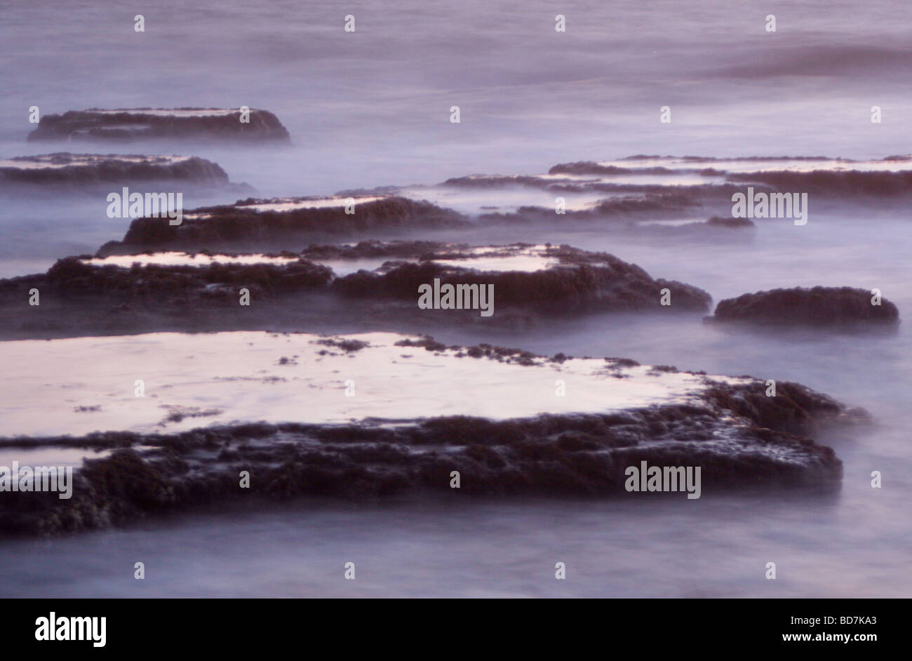 Langzeitbelichtung der Felsen im Meer in der Abenddämmerung Stockfoto