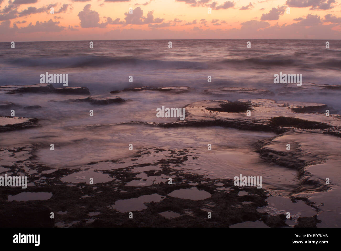 Langzeitbelichtung der Felsen im Meer in der Abenddämmerung Stockfoto