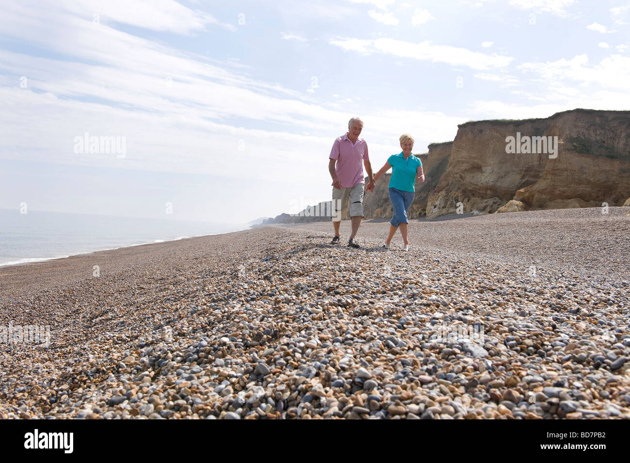 Älteres Paar zu Fuß am Kiesstrand Stockfoto