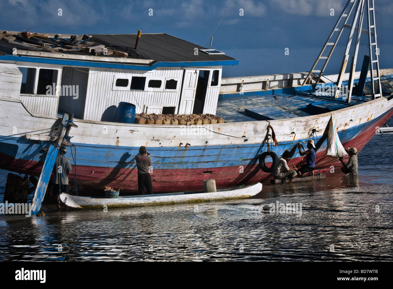 Indonesien Sulawesi Tanah Beru in der Nähe von Pantai Bira Bira Beach traditionelle hölzerne Bootsbau Männer Boot Reparatur Stockfoto