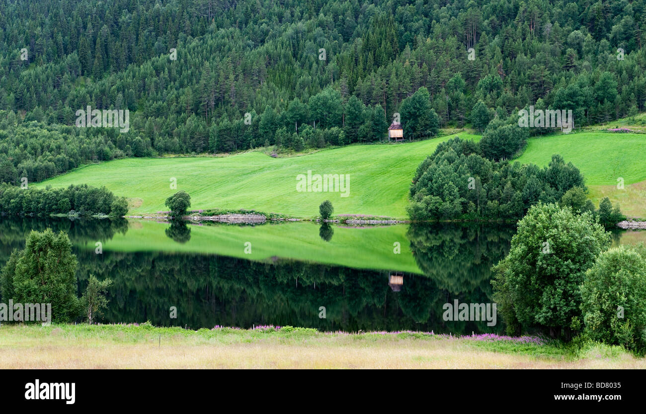 Eine Scheune spiegelt sich in den ruhigen Gewässern eines Sees in den Bergen bei Lillehammer, Norwegen Stockfoto
