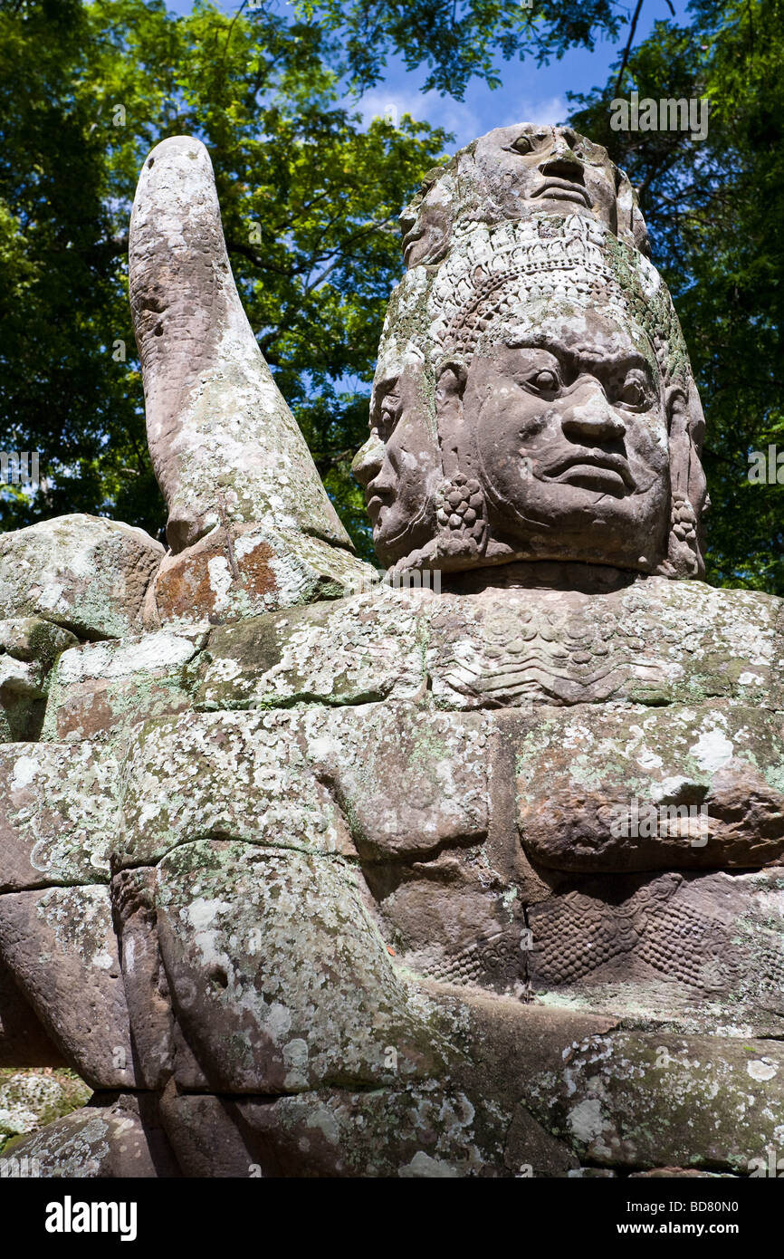 Eine steinerne Wächter am Ende einer Brücke über den massiven einschließenden Graben in der Nähe von Angkor Thom Stockfoto