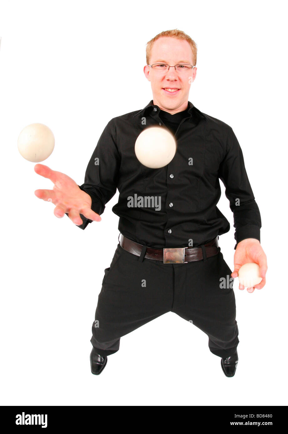 junger Mann mit drei Bällen jonglieren Stockfoto