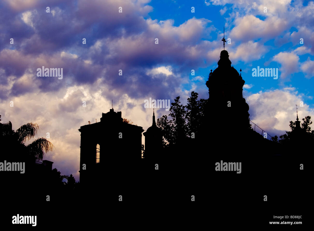 Kirchturm Hintergrundbeleuchtung und Wolken Stockfoto