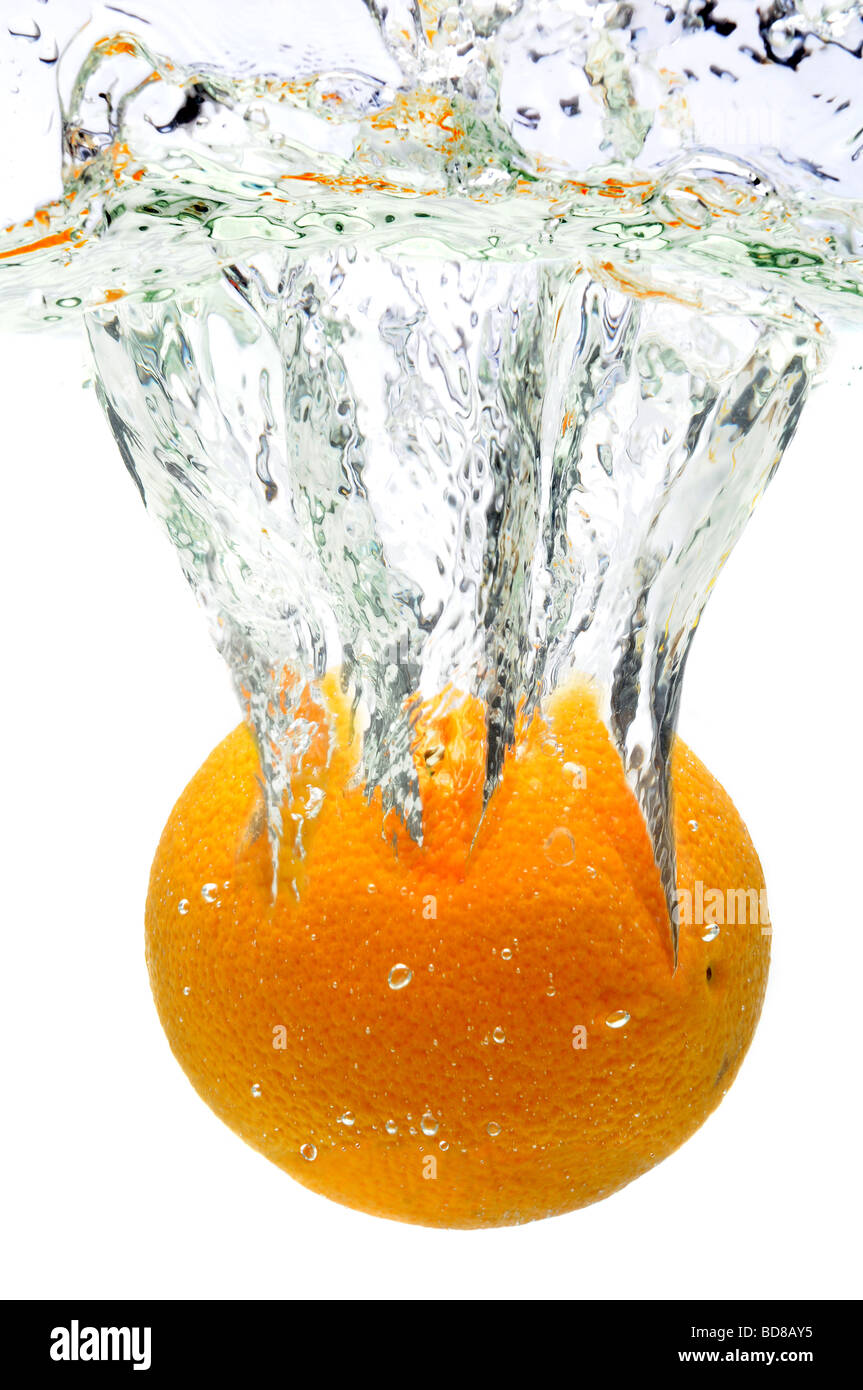 Orange spritzt ins Wasser über einen weißen Hintergrund Stockfoto