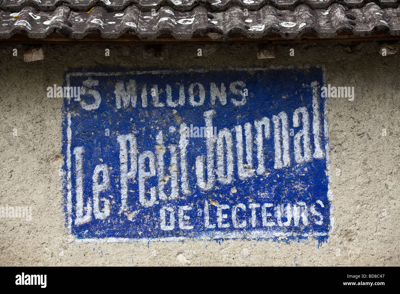 Eine alte bemalte Werbung für eine französische Tageszeitung der Vergangenheit (Allier - Frankreich). Vieille Publicité Peinte pour un Quotidien. Stockfoto