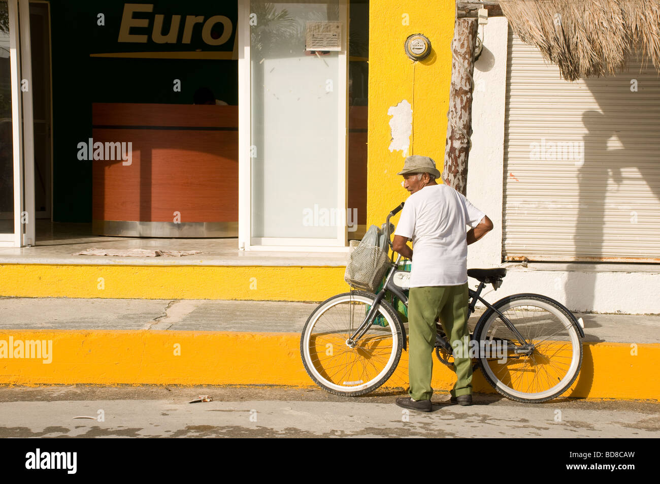 Ein älterer Mann bereitet sich auf sein Fahrrad nach Hause zurückkehren, nach dem Kauf seiner Produkte auf dem Bauernmarkt in Puerto Morelos, Mexiko Stockfoto