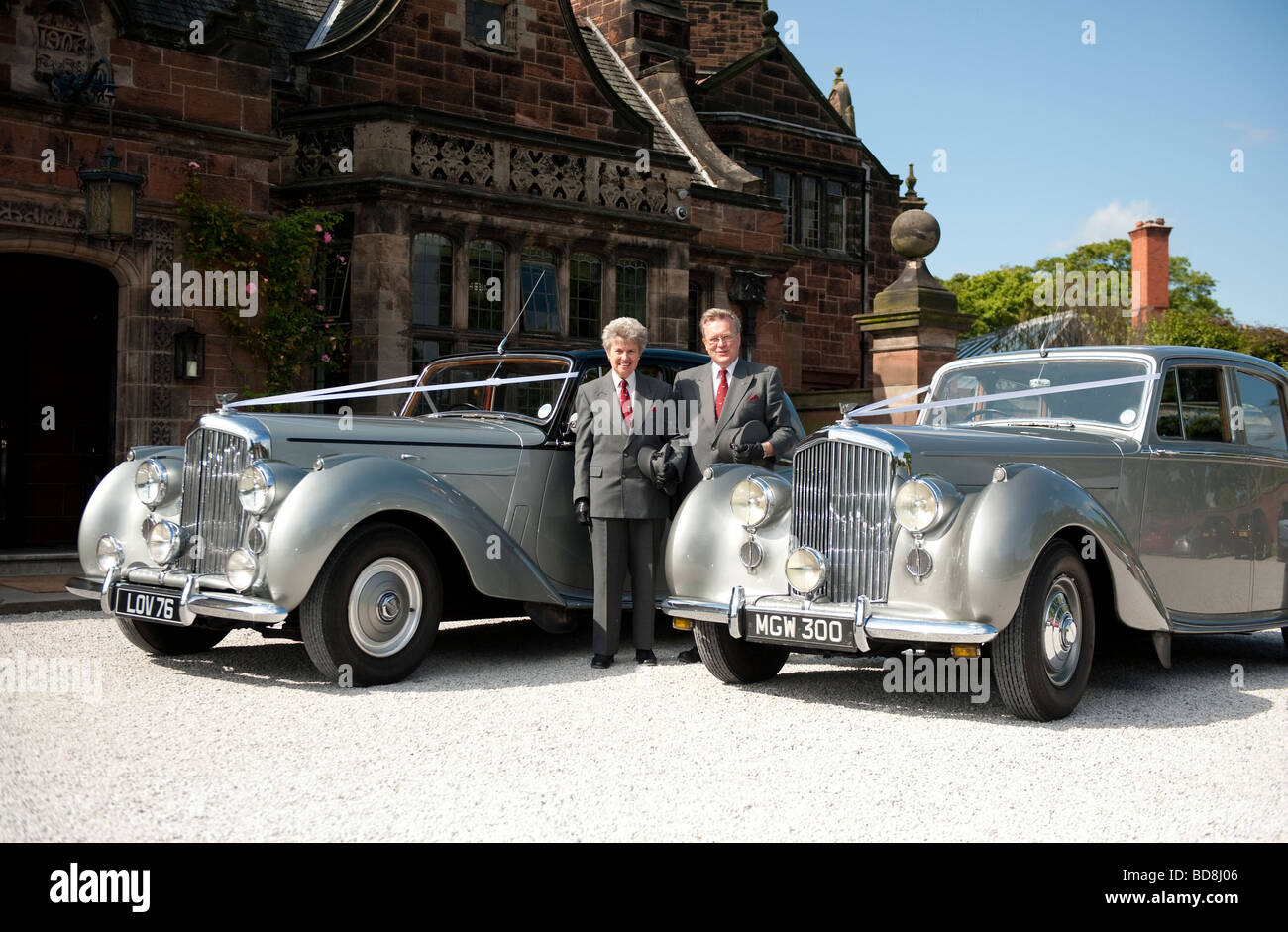 Zwei Chauffeure mit alten Bentleys außerhalb großes Landhaus Stockfoto