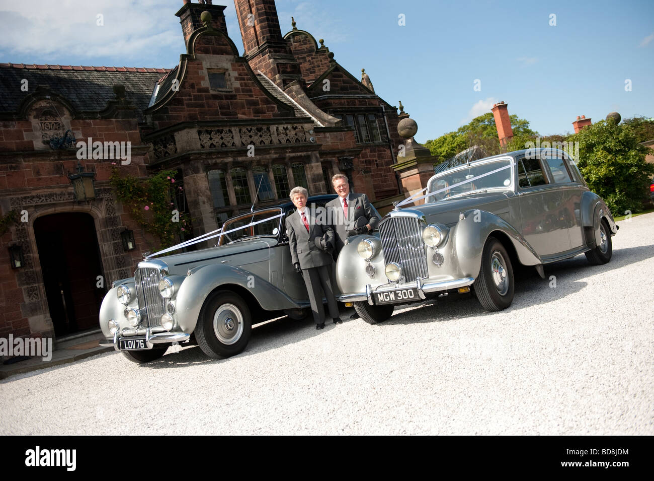 Zwei Chauffeure mit alten Bentleys außerhalb großes Landhaus Stockfoto