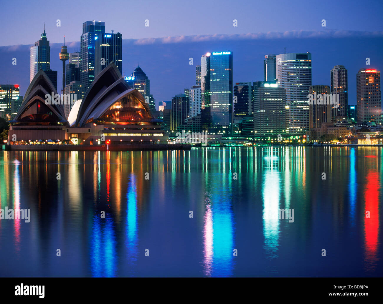 Helle Nachtlichter reflektiert Skyline von Sydney Opernhaus was in ruhigen Gewässern der Hafen Stockfoto
