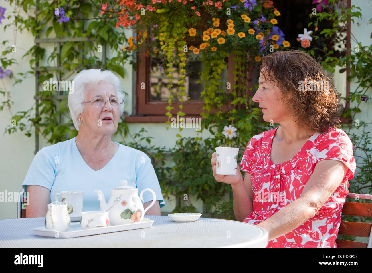 Damen Tee zu trinken, in einem Garten in Clitheroe Lancashire UK Stockfoto