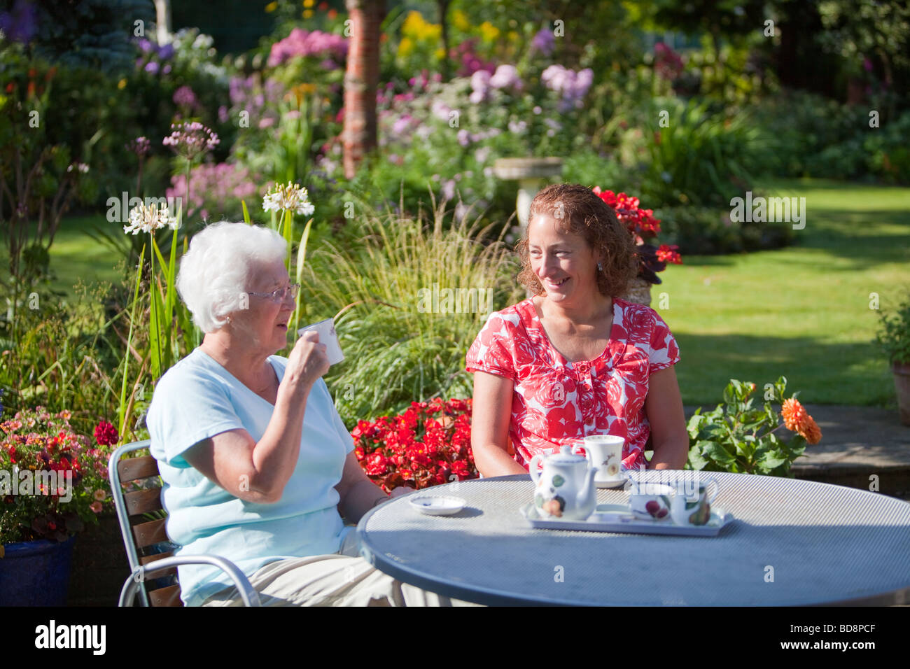 Damen Tee zu trinken, in einem Garten in Clitheroe Lancashire UK Stockfoto