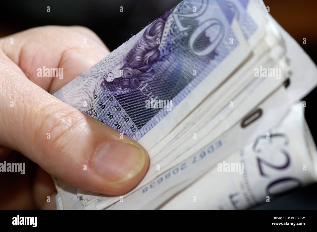 Hand hält ein Bündel von britischen Pfund Sterling Banknoten Stockfoto