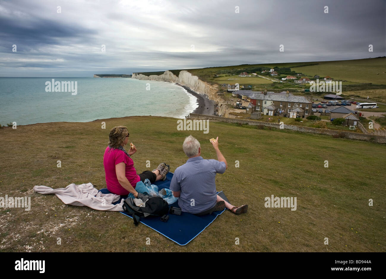 Birling Gap East Sussex Großbritannien Besucher Picknick über Birling Gap unter einem bedrohlichen Himmel Küstenerosion Stockfoto