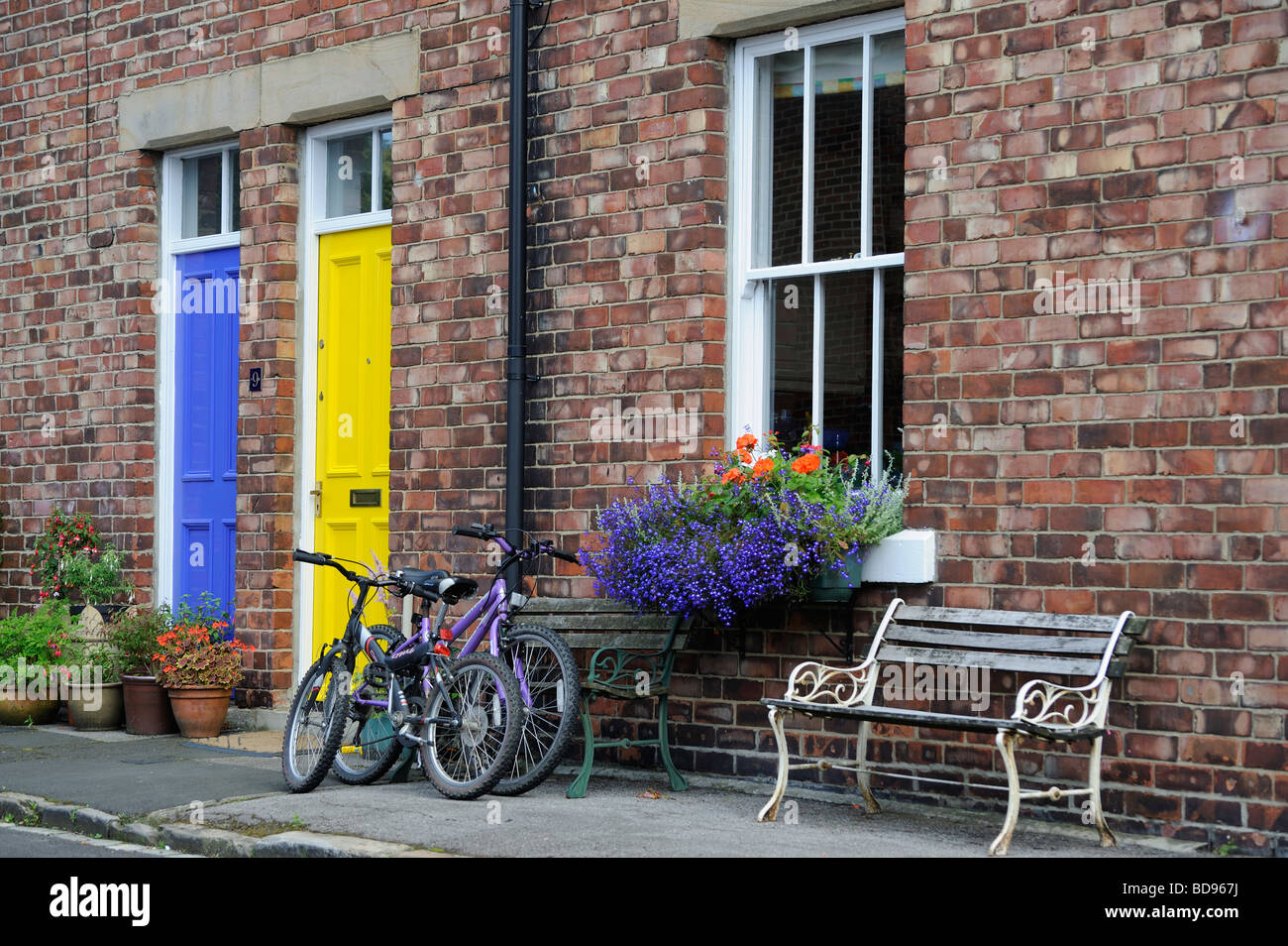 Durham City gelbe und blaue Tür mit zwei Fahrräder vor der Haustür von einem Reihenhaus Terrasse Wanless Stockfoto