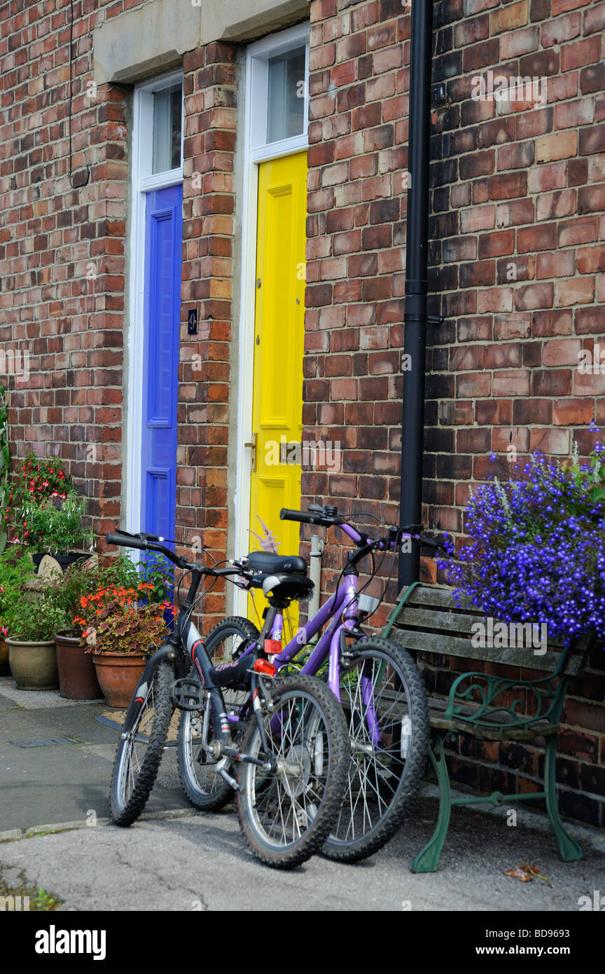 Durham City gelbe und blaue Tür mit zwei Fahrräder vor der Haustür von einem Reihenhaus Terrasse Wanless Stockfoto