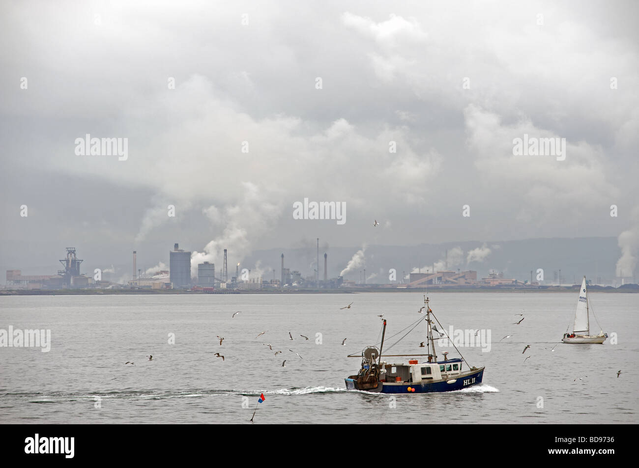 Angelboot/Fischerboot Segeln in den Fluss Tees vorbei an das Stahlwerk Corus in Redcar, Cleveland, UK. Stockfoto