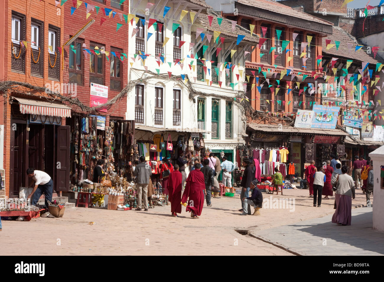 Bodhnath, Nepal.  Souvenir-Shops, Reisebüros, kleinen Restaurants umgeben Gehweg, wo Besucher die Stupa umrunden. Stockfoto