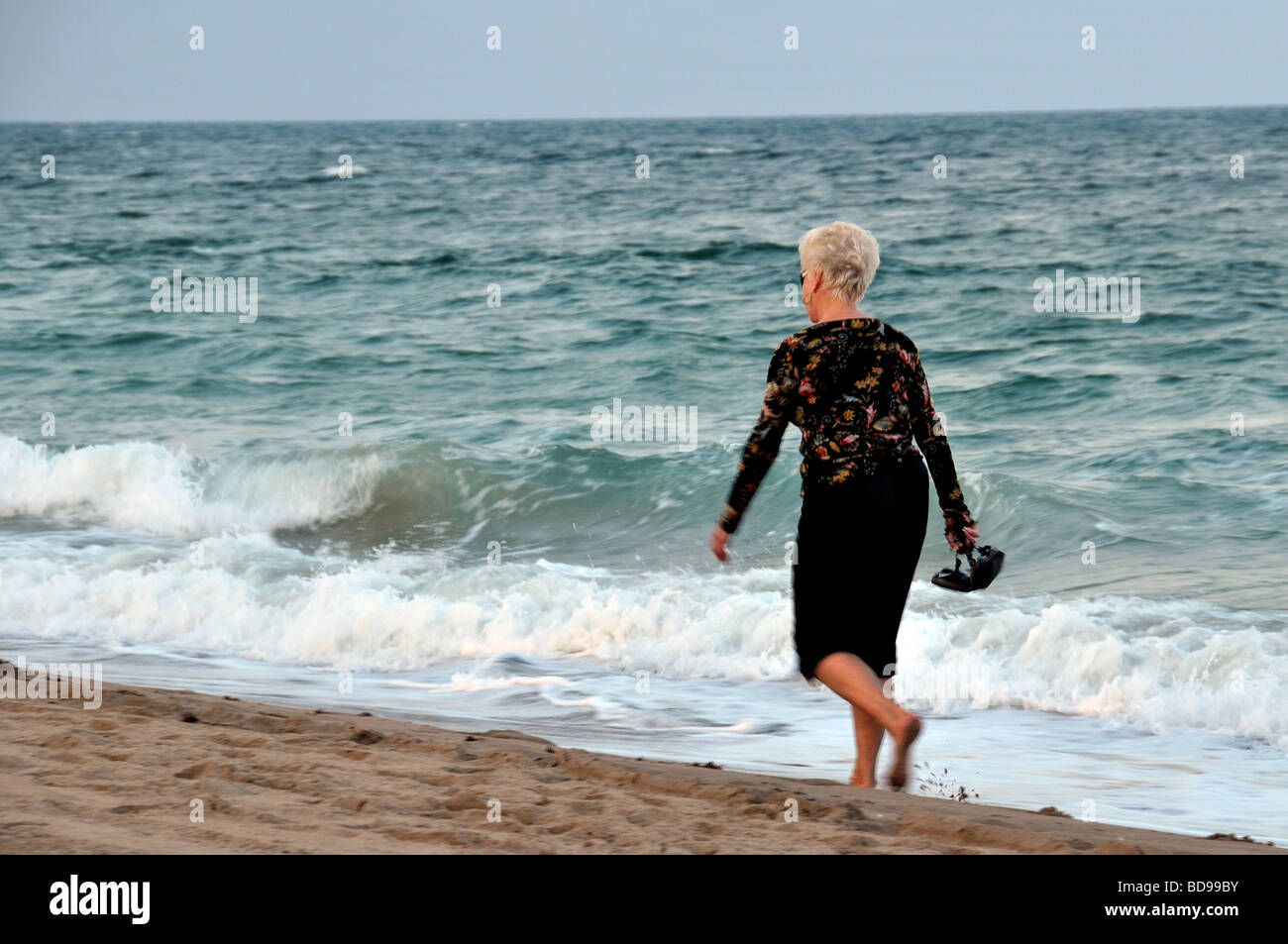 Reife Frau bei einem Spaziergang am Strand in Florida. Stockfoto