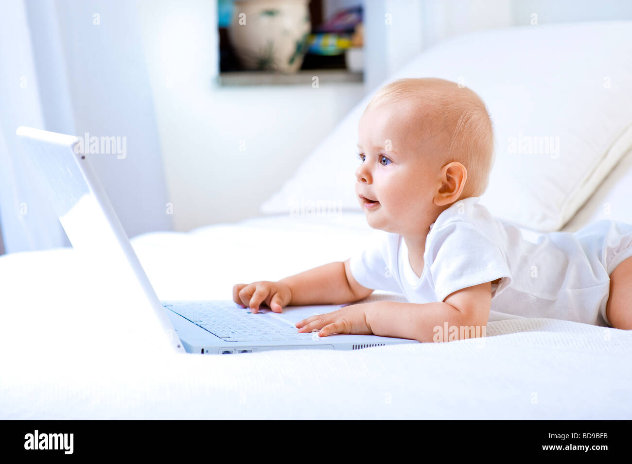 Baby Bett vor Laptop liegend, als ob arbeiten Stockfoto