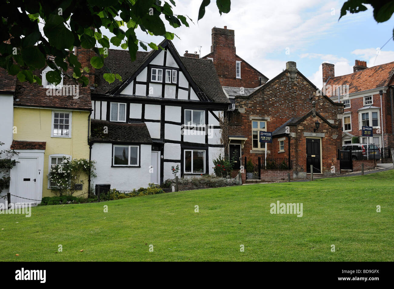 Altes Fachwerk Häuser durch die grüne, Marlborough, Wiltshire, England, UK Stockfoto