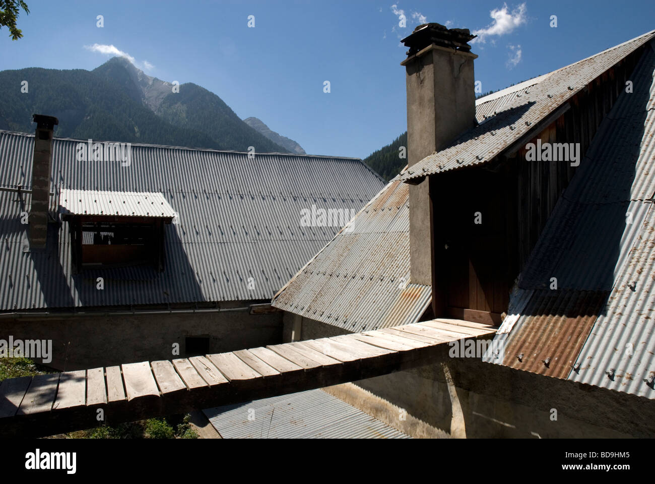 Steile Wellblechdächern und Gehweg in alpinen Dorf in der Nähe von Barcellonette, Alpes-de-Haute-Provence Frankreich Stockfoto