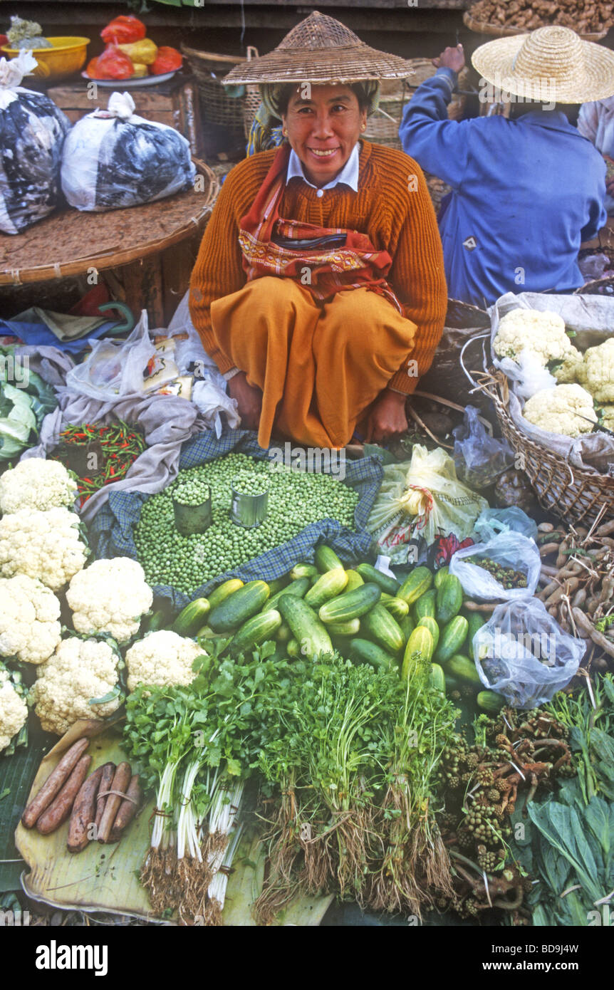 Burmesische Frau, trägt traditionelle Strohhut, Verkauf von lokalen Gemüse auf dem Markt von Myitkyina im Norden Myanmars Stockfoto