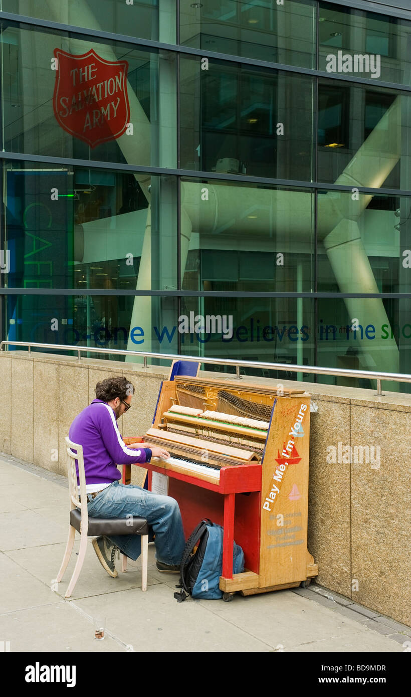 Ein Londoner Straße Klavierspieler an einem öffentlichen Ort außerhalb der Heilsarmee Gebäude im zentralen London UK Stockfoto