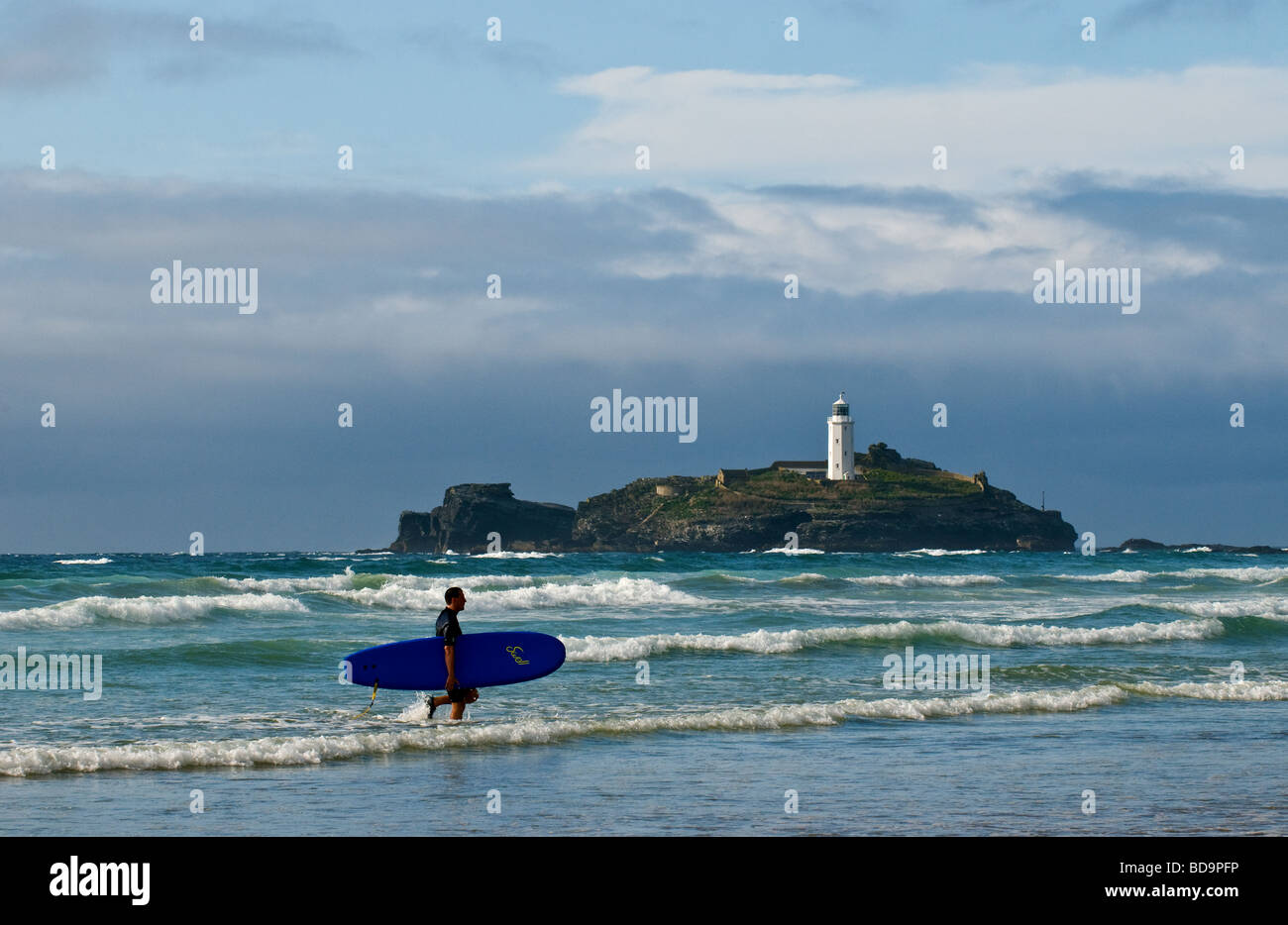 Ein Surfer im Meer am Strand von Gwithian Towans in Cornwall. Stockfoto