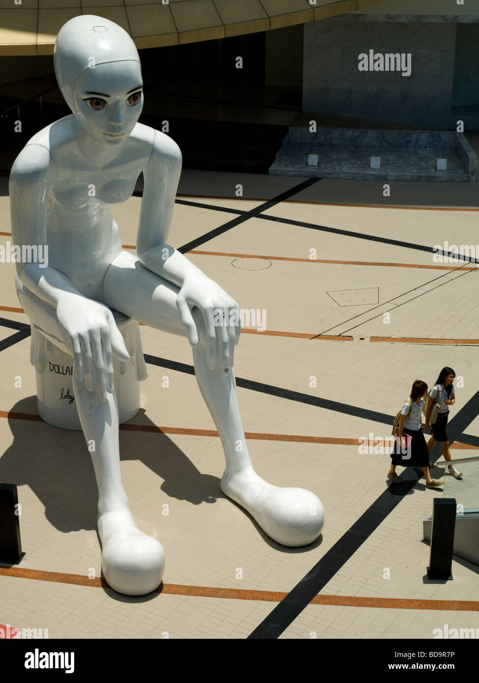 Statue außerhalb der Art Gallery in Siam Square Bangkok Thailand. Zwei Schulmädchen gehen am Fuße der Skulptur. Stockfoto