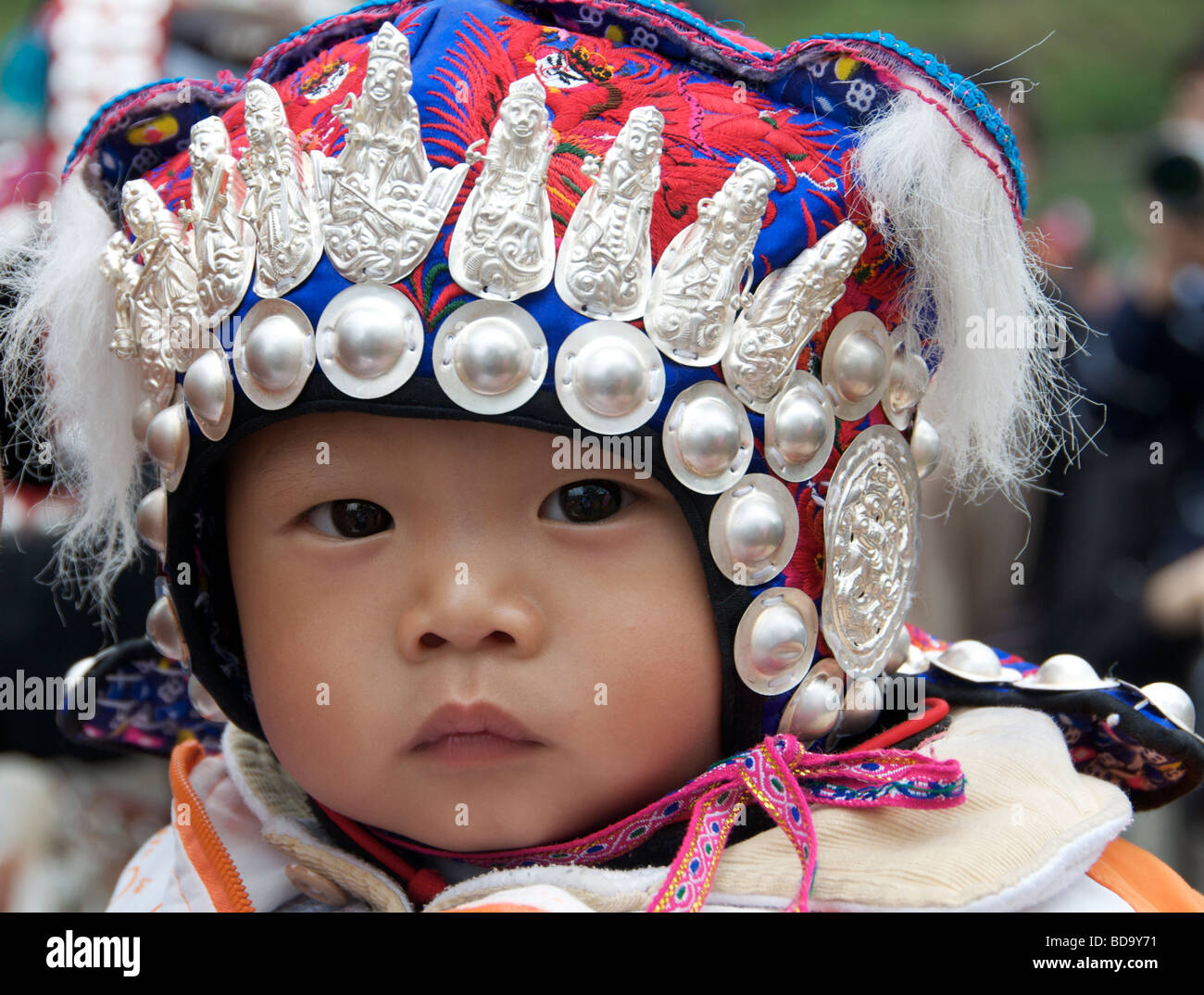 Miao Baby mit kunstvollen Kopfschmuck Drum Festival Shidong Guizhou Provinz China hautnah Stockfoto