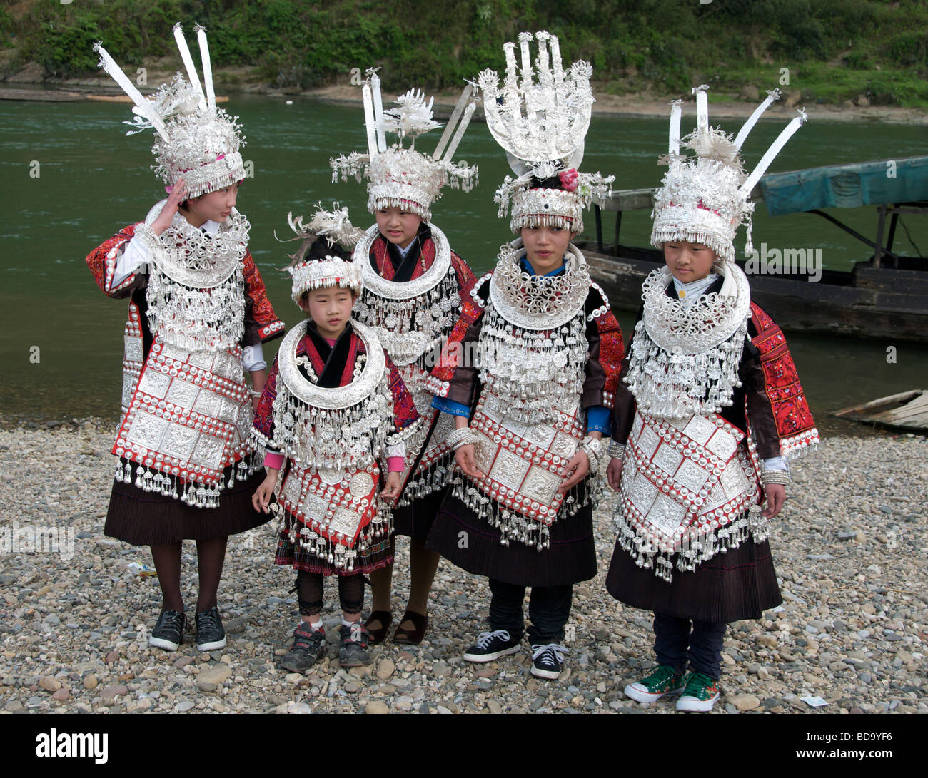 Fünf Mädchen in Abendkleidung am Flussufer posiert für Fotos in der Provinz Guizhou Miao Drum Festival Shidong China Stockfoto
