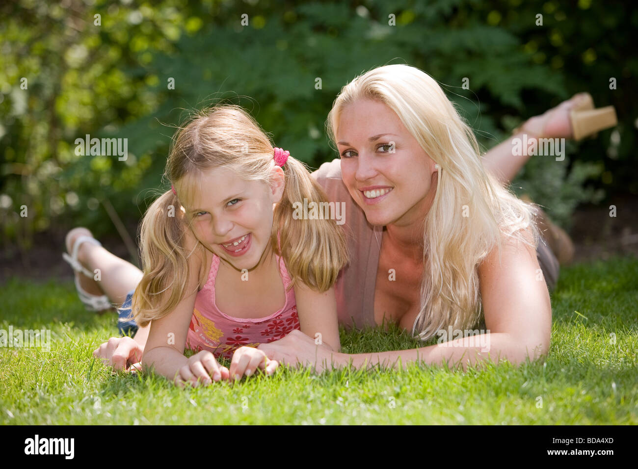 Blonde Mutter mit ihrer Tochter an einem Sommertag auf der Wiese liegend Stockfoto