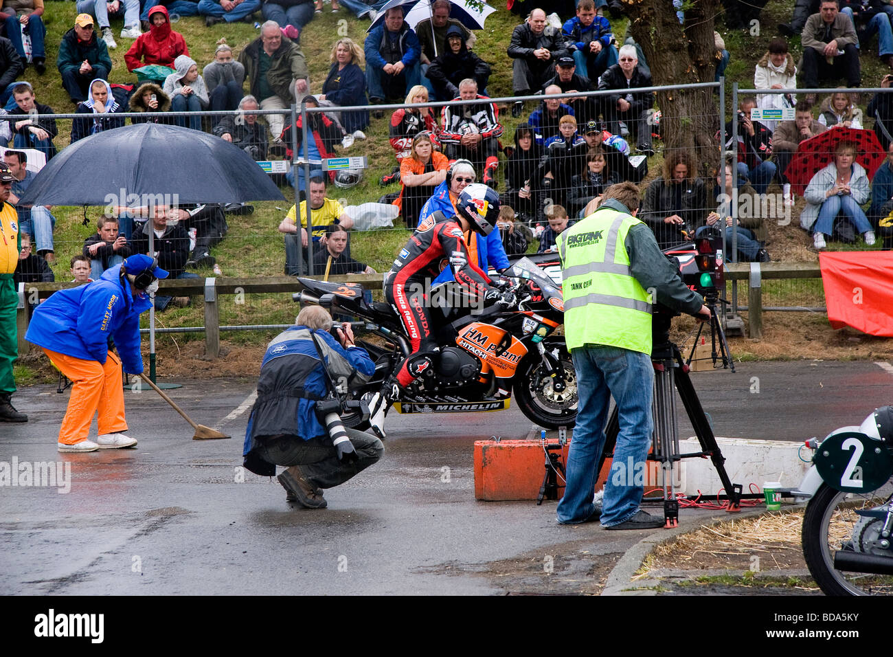 Jonathan Rae nimmt seinerseits im Regen in Northwich Thundersprint, während Beamte und Fotografen, die ihn verfolgen Stockfoto