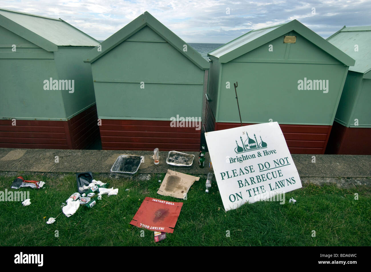 Chaos und Müll von Strandhütten auf Hove Rasen, neben einer Bekanntmachung, die Leute nicht zum Grillen auf dem Rasen zu Fragen. Stockfoto