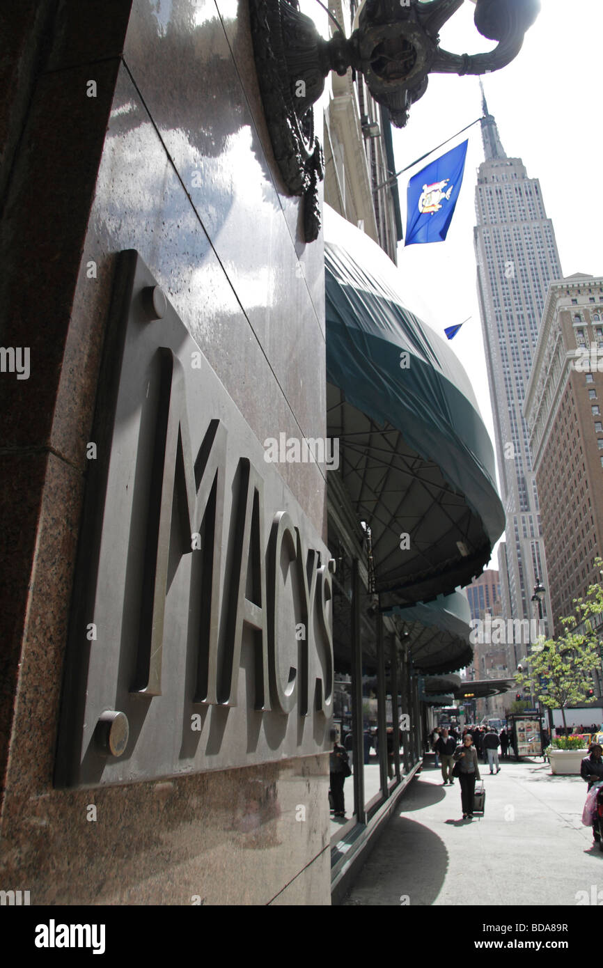 Eine Schrägansicht der Macy Eingang melden Sie an der 34th Street mit dem Empire State Building hinter New York. Stockfoto