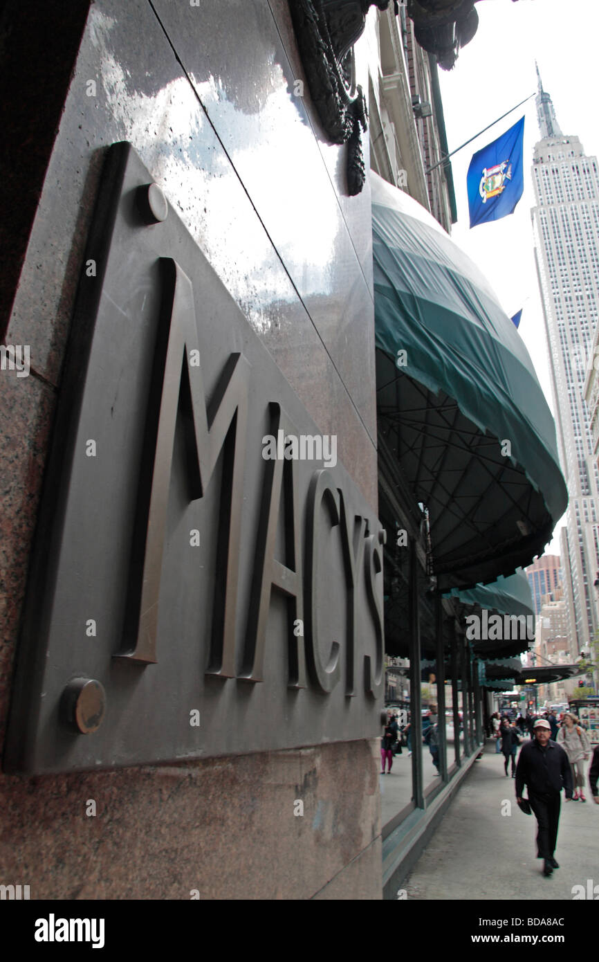 Eine Schrägansicht der Macy Eingang melden Sie an der 34th Street mit dem Empire State Building hinter New York. Stockfoto