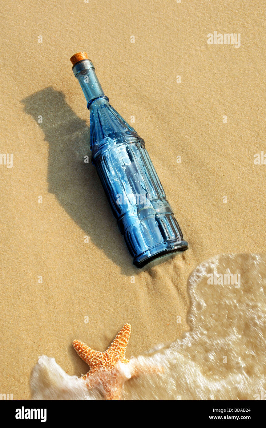 Vintage Flasche mit einer Nachricht und Seesterne am Ufer Stockfoto