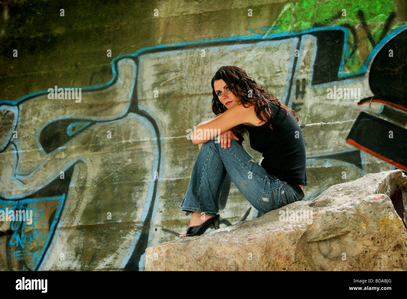 Frau sitzt auf großen Felsen umgeben von graffiti Stockfoto