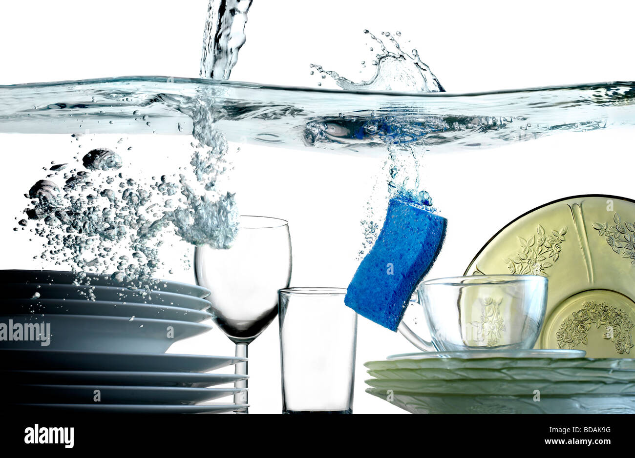 Wasser gießen in eine Wanne voller Teller Gläser Schalen und einem blauen Schwamm absteigend ins Becken Stockfoto