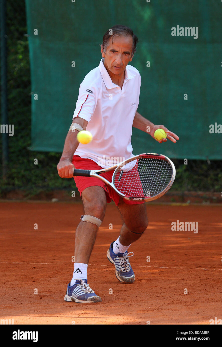 Älterer Mann spielen eine Rückhand beim Tennisturnier Stockfoto