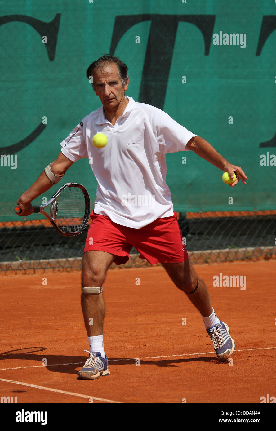 Älterer Mann spielt bei einem Tennisturnier Stockfoto