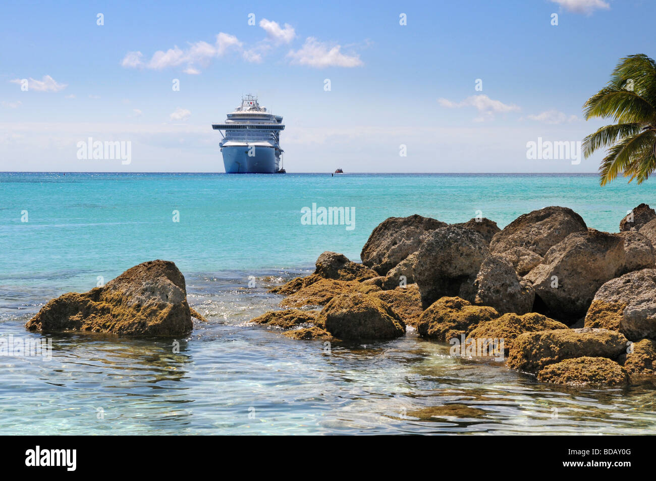 Tropischen Felsenstrand mit Kreuzfahrtschiff im Hintergrund Stockfoto