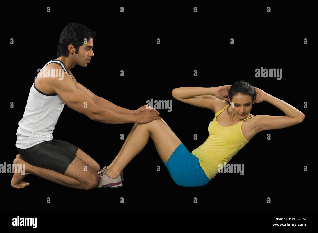 Männliche Lehrer hilft Frau dabei Sit-ups Stockfoto