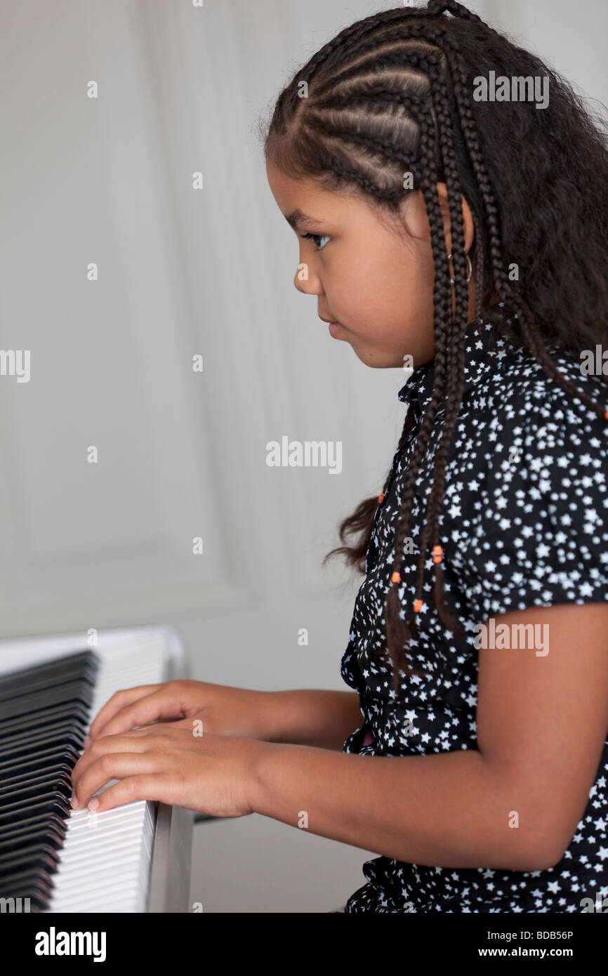 Kleines Mädchen ist das e-Piano spielen. Stockfoto