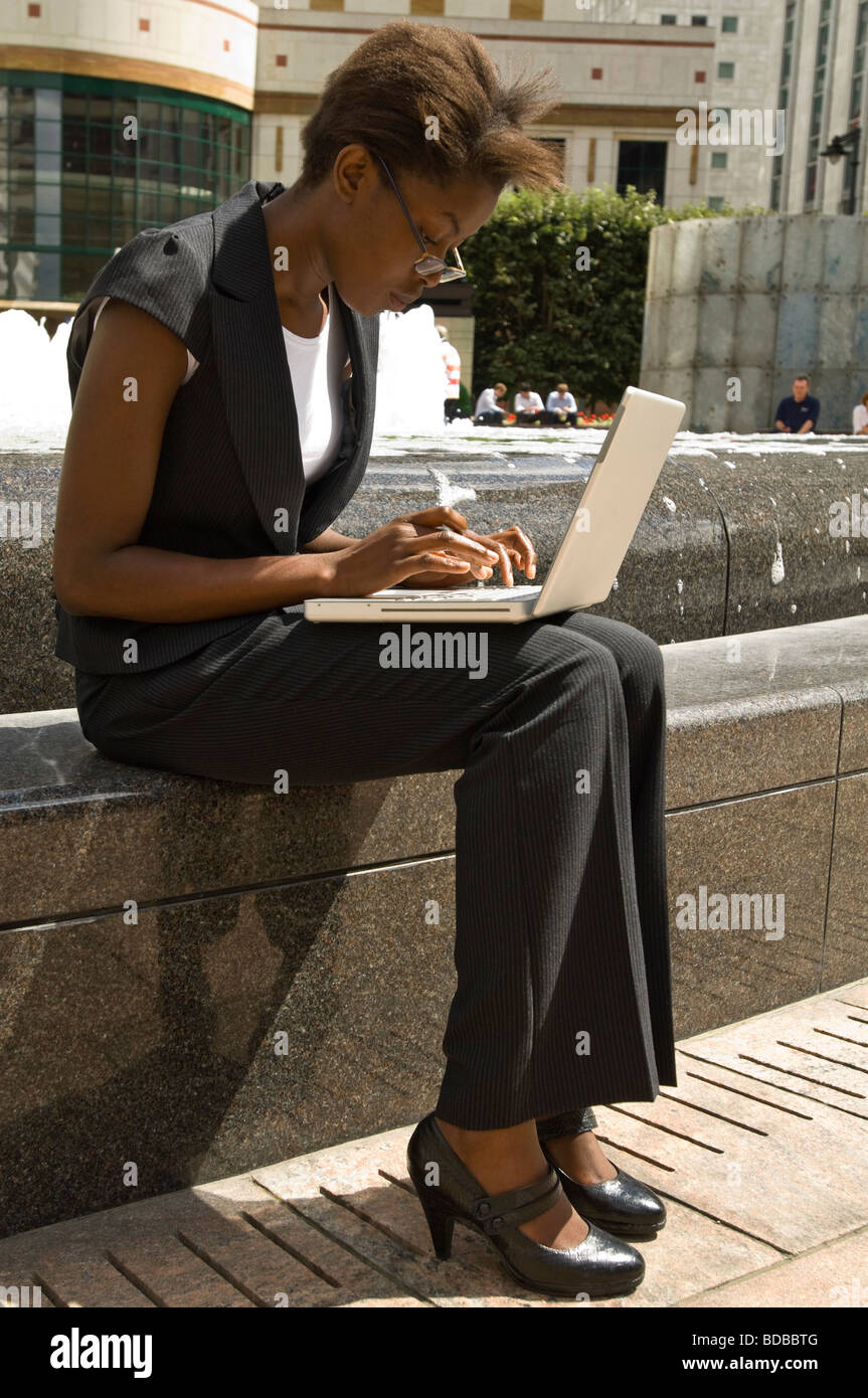 Vertikal nah Porträt einer attraktiven jungen African Business-Frau mit ihrem Laptop-Computer draußen in der Sonne Stockfoto